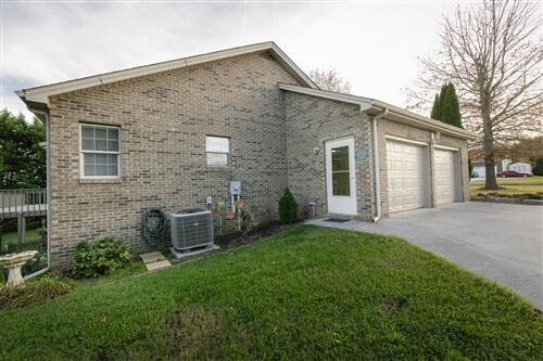 view of property exterior featuring a yard, a garage, and central air condition unit