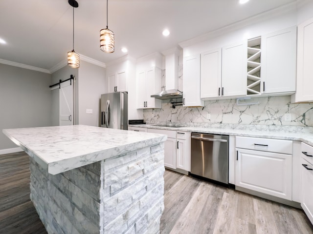 kitchen featuring stainless steel appliances, tasteful backsplash, a barn door, a kitchen island, and a sink