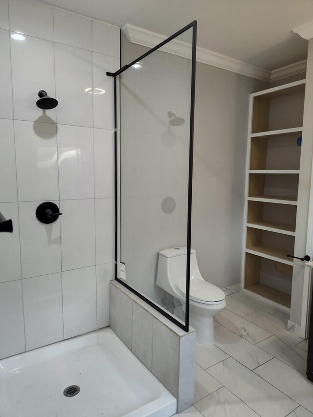 bathroom with vanity, toilet, ornamental molding, and tiled shower