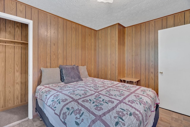 bedroom featuring a textured ceiling, light colored carpet, and wood walls