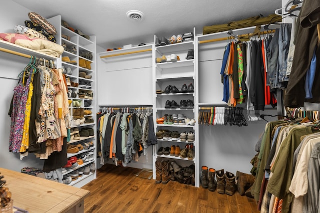 walk in closet with hardwood / wood-style floors