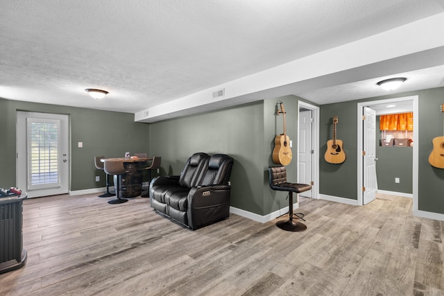 living room featuring light hardwood / wood-style floors and a textured ceiling