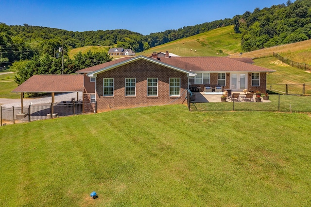 back of house with outdoor lounge area, a yard, and a patio