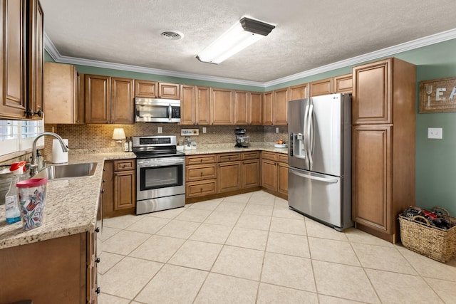 kitchen featuring sink, light stone countertops, a textured ceiling, ornamental molding, and appliances with stainless steel finishes