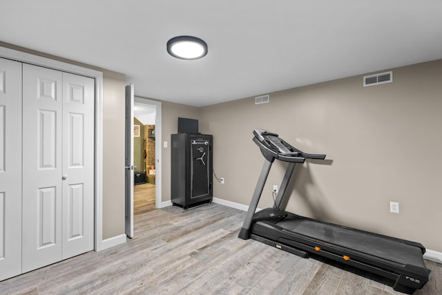 workout area with light hardwood / wood-style flooring