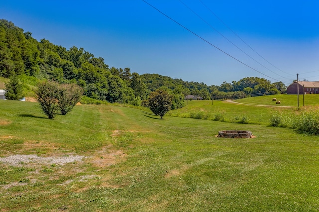 view of yard with a rural view and a fire pit