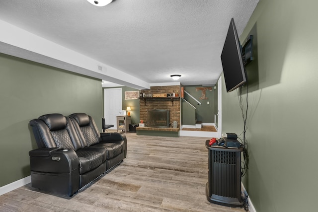 living room with a fireplace, a textured ceiling, and hardwood / wood-style flooring