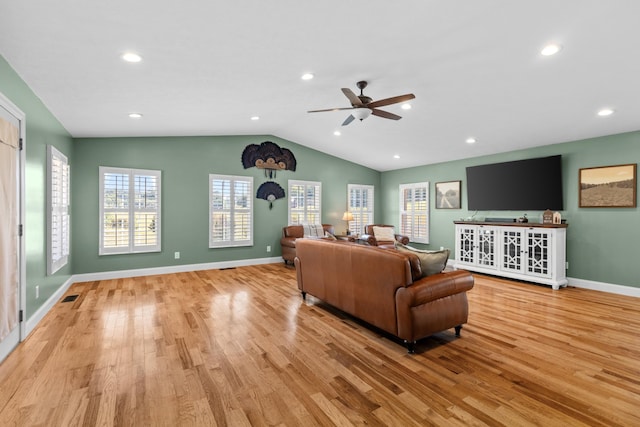 living room featuring ceiling fan, light hardwood / wood-style floors, and vaulted ceiling