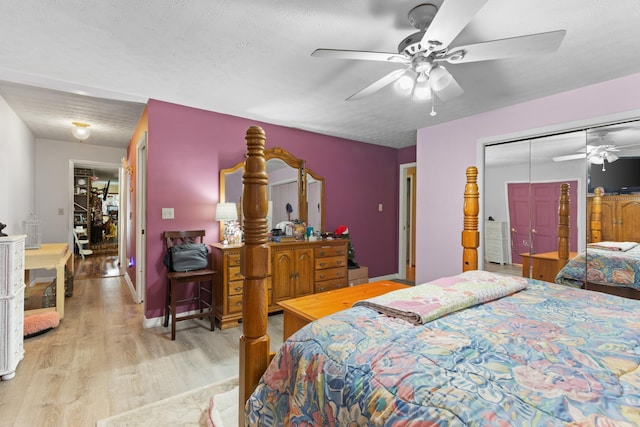 bedroom featuring ceiling fan, a closet, a textured ceiling, and light wood-type flooring