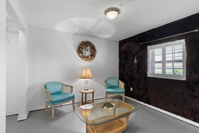 living area featuring concrete floors and a textured ceiling