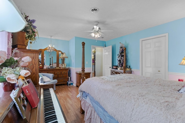 bedroom featuring a closet, ceiling fan, light hardwood / wood-style flooring, and a textured ceiling