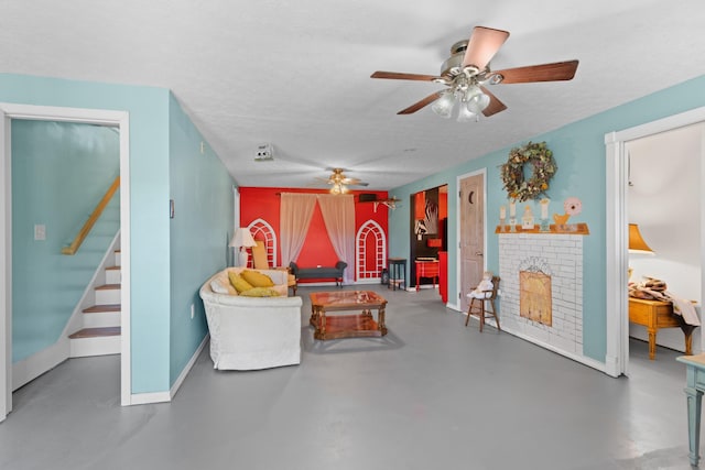 rec room with ceiling fan, concrete flooring, and a textured ceiling