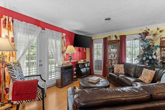 living room featuring hardwood / wood-style floors, a textured ceiling, and ornamental molding