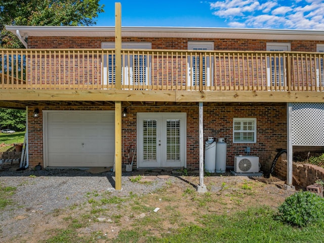 rear view of house with ac unit, a garage, and a wooden deck