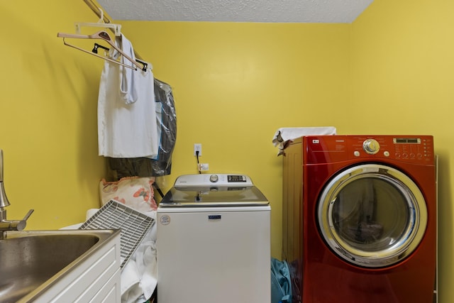 washroom featuring a textured ceiling, separate washer and dryer, and sink