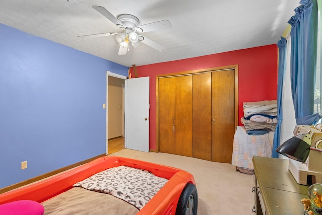 carpeted bedroom with ceiling fan, a closet, and a textured ceiling