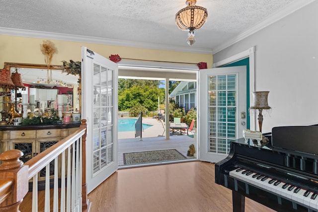 entryway with french doors, hardwood / wood-style floors, a textured ceiling, and ornamental molding