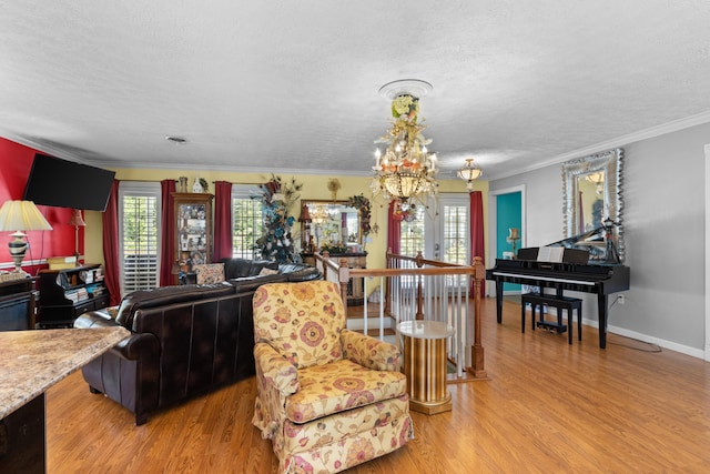 living room with light wood-type flooring, an inviting chandelier, a wealth of natural light, and crown molding