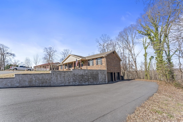 view of front of home with a garage, driveway, and brick siding