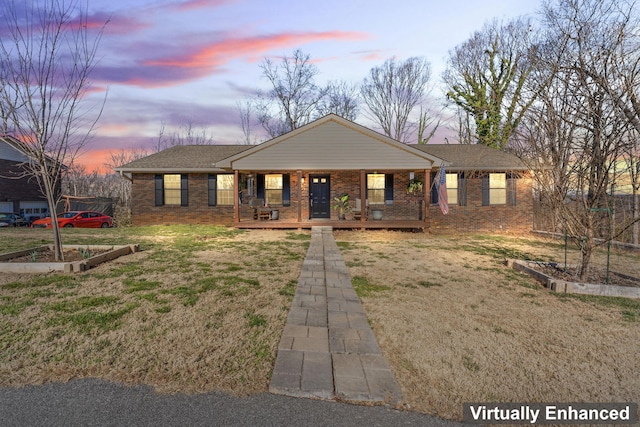 view of front of property with a porch, a front lawn, a vegetable garden, and brick siding