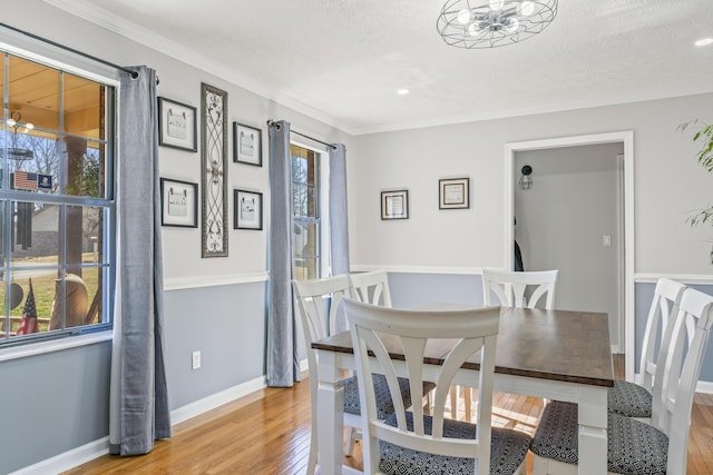 dining area with a textured ceiling, light wood finished floors, and baseboards