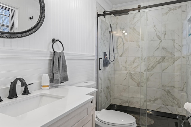 full bath featuring a stall shower, wainscoting, vanity, and toilet