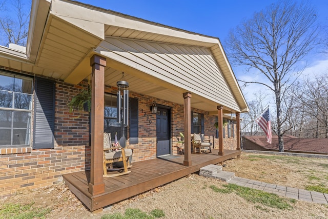 exterior space with a porch and brick siding