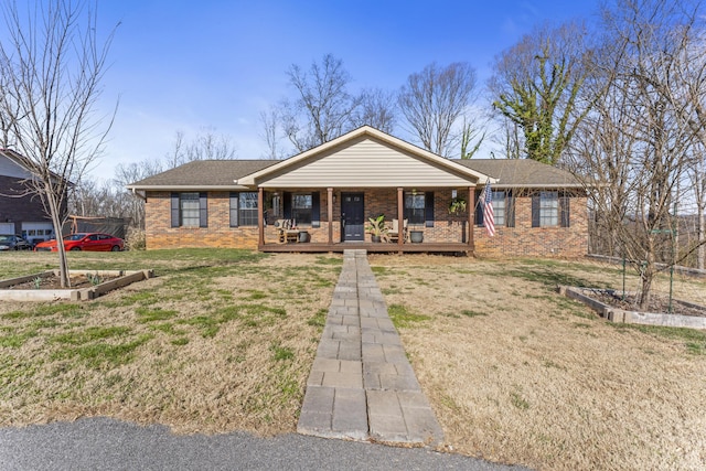 ranch-style house featuring covered porch, a shingled roof, a front yard, and brick siding