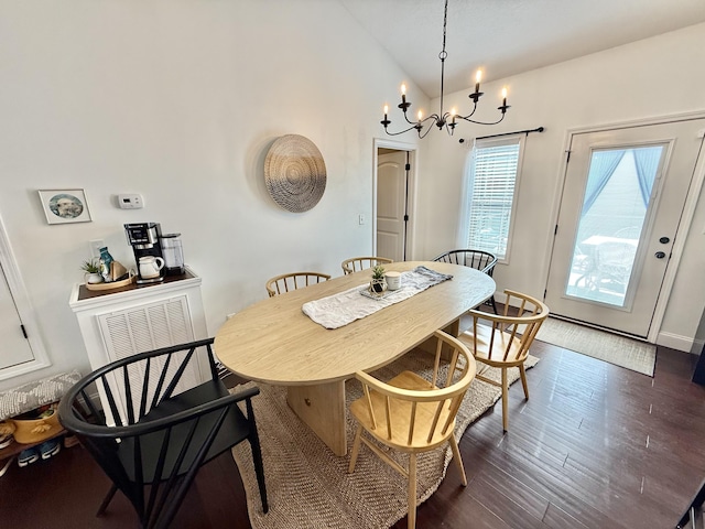 dining room featuring a chandelier, lofted ceiling, and dark wood-type flooring