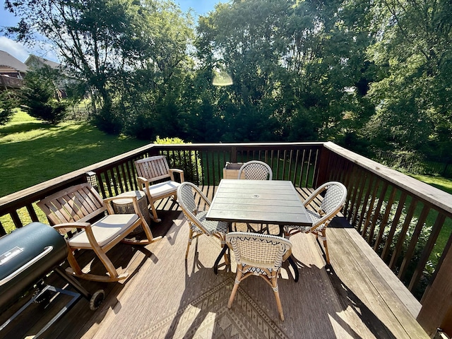 wooden deck with a lawn and outdoor dining space