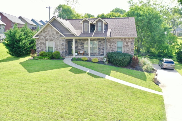 view of front facade featuring a front yard, brick siding, and covered porch