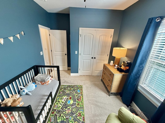 bedroom with light colored carpet, a closet, baseboards, and multiple windows