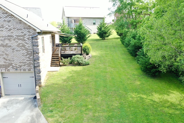 view of yard with driveway, stairway, and a wooden deck
