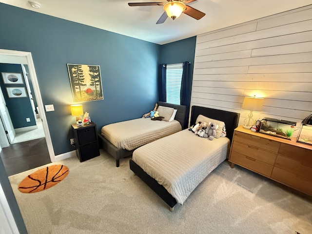 bedroom with a ceiling fan, light carpet, and baseboards