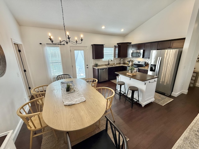 dining area with baseboards, dark wood-style flooring, a chandelier, and vaulted ceiling