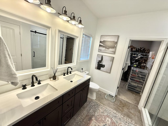 bathroom featuring a sink, double vanity, a spacious closet, and a stall shower
