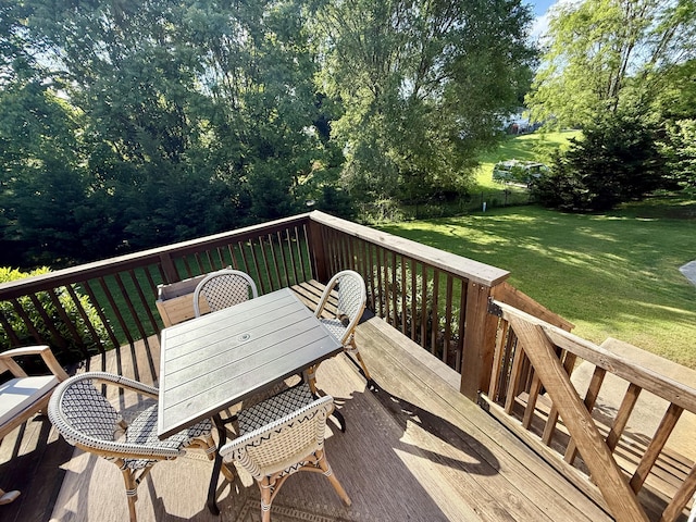 wooden deck with outdoor dining space and a lawn