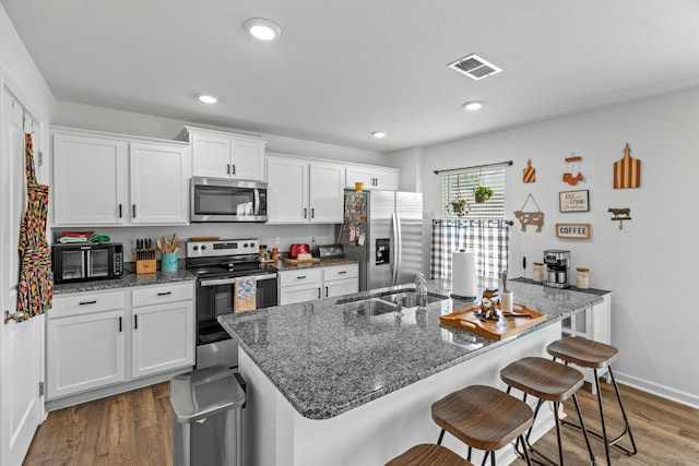 1065 Greenway Dr, Morristown, TN 37813 - kitchen featuring a kitchen breakfast bar, white cabinetry, a sink, visible vents, and stainless steel appliances