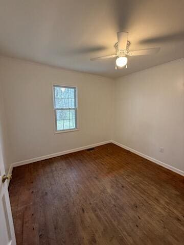 empty room featuring ceiling fan, baseboards, and dark wood-style flooring