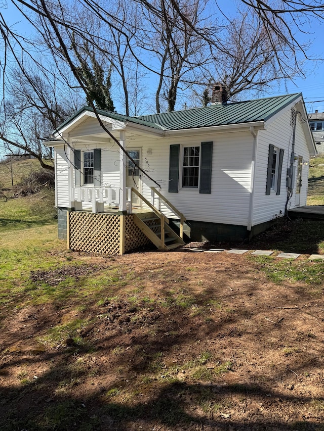 view of front of property featuring metal roof and a chimney