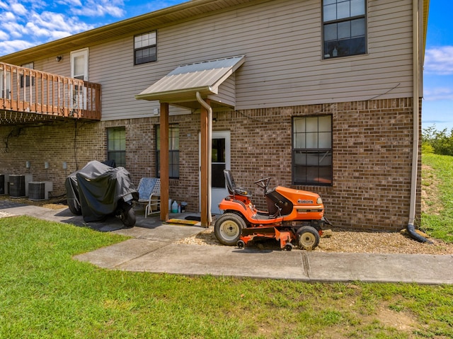 back of house featuring a lawn, a patio area, and a deck