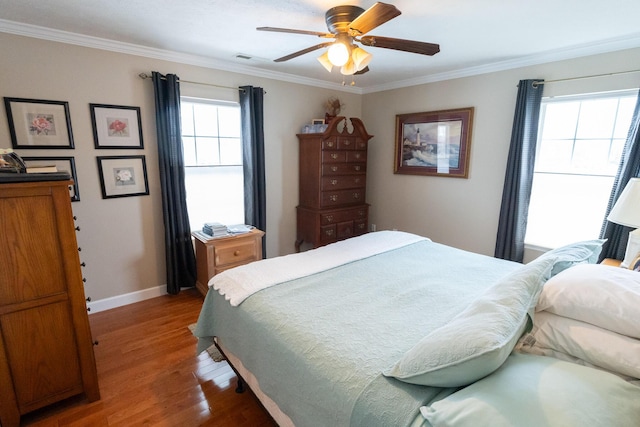 bedroom featuring ceiling fan, hardwood / wood-style floors, and ornamental molding