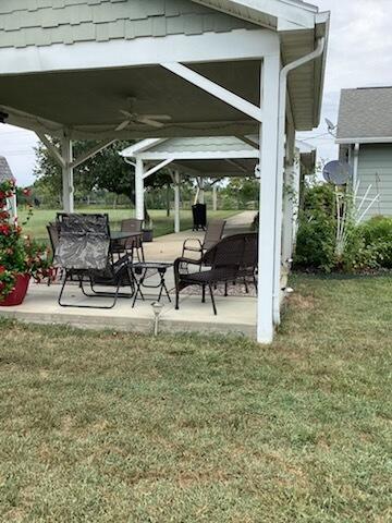 view of yard with a patio area and ceiling fan