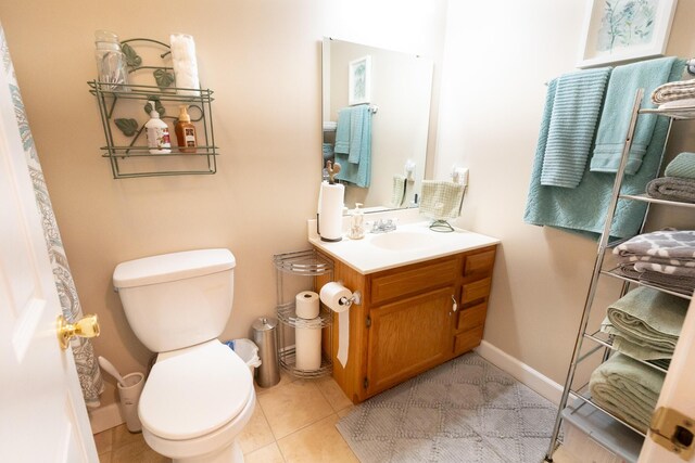 bathroom with toilet, tile patterned flooring, and vanity