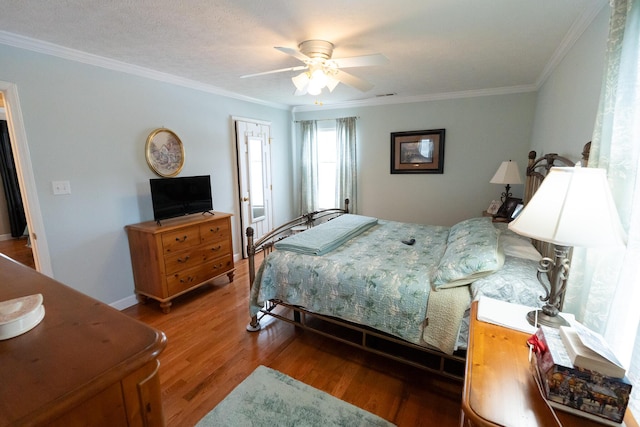 bedroom with a textured ceiling, ceiling fan, wood-type flooring, a closet, and crown molding