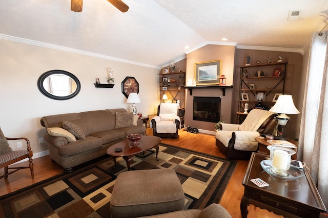 living room with hardwood / wood-style flooring, ceiling fan, vaulted ceiling, and ornamental molding