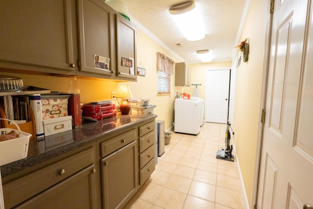 laundry room with washing machine and dryer, light tile patterned floors, and crown molding