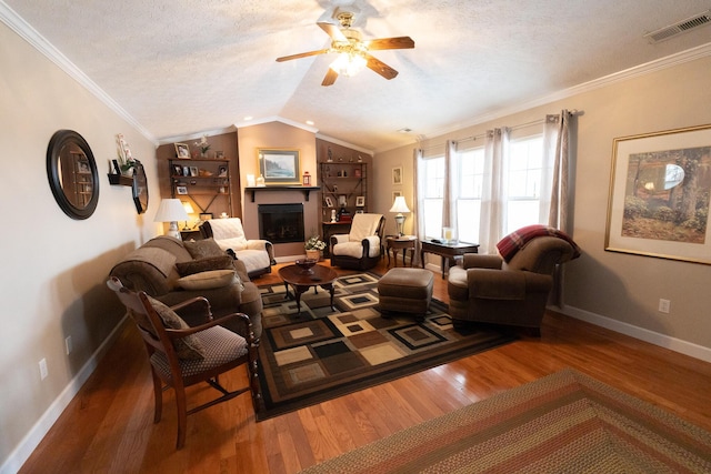 living room featuring lofted ceiling, a textured ceiling, ornamental molding, and wood-type flooring