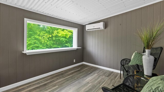 261 Buzzard Roost Rd, Bulls Gap, TN 37711 - sitting room featuring a wall unit AC, wood finished floors, baseboards, and wooden walls