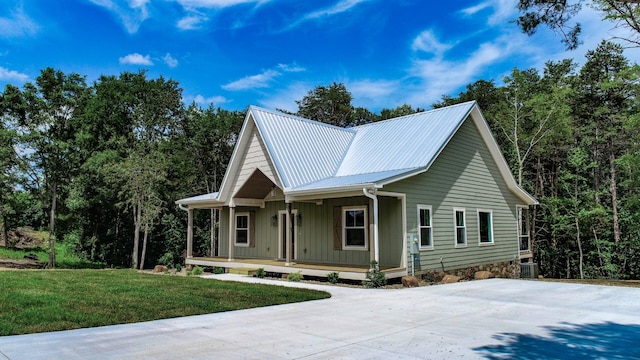 1056 Old Newport Hwy, Dandridge, TN 37725 - view of front of house with covered porch, concrete driveway, board and batten siding, a front yard, and a metal roof